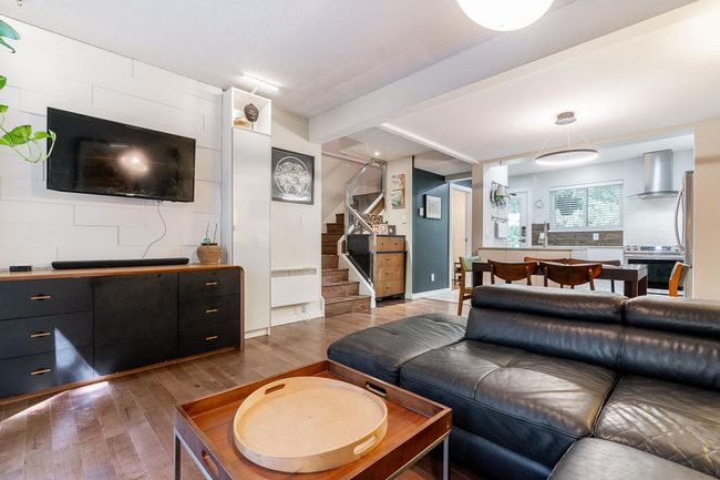 Living area with wood finished floors, stairway, baseboards, and beamed ceiling | Image 5
