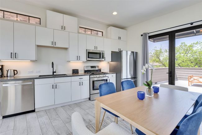 Kitchen featuring appliances with stainless steel finishes, recessed lighting, white cabinets, and dark countertops | Image 20