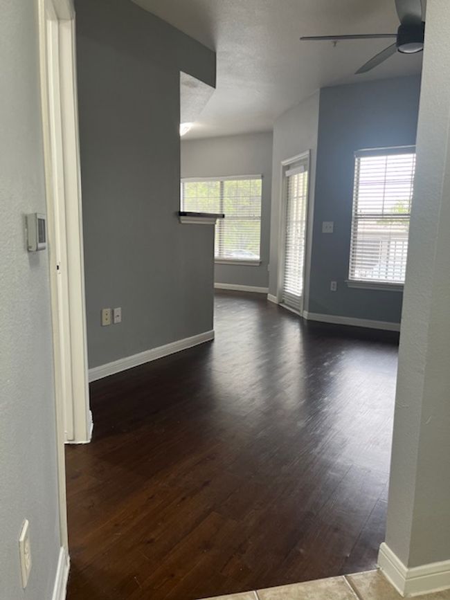 Spare room with ceiling fan, baseboards, and dark wood-style flooring | Image 4