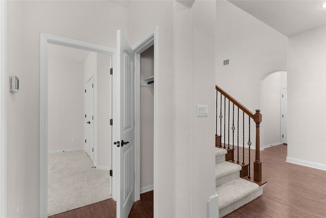 Stairs featuring arched walkways, visible vents, baseboards, and wood finished floors | Image 9