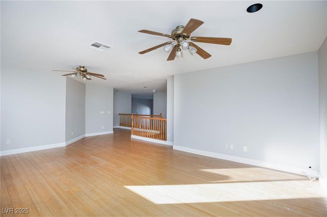 Unfurnished room featuring light wood finished floors, baseboards, a ceiling fan, and visible vents | Image 23