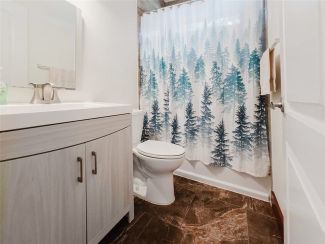 Full bath featuring vanity, marble look tile flooring, and shower / bath combo | Image 31