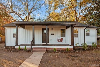 View of front of house featuring a welcoming full porch. Board & Batten siding, new windows, front door and roof. | Image 1