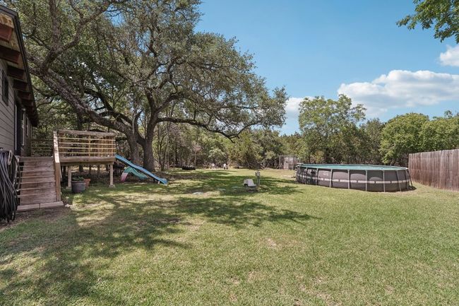 View of yard with a playground, stairway, and an outdoor pool | Image 26