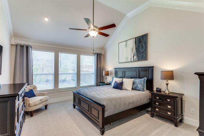 Bedroom featuring vaulted ceiling, ornamental molding, light carpet, and a ceiling fan | Image 20