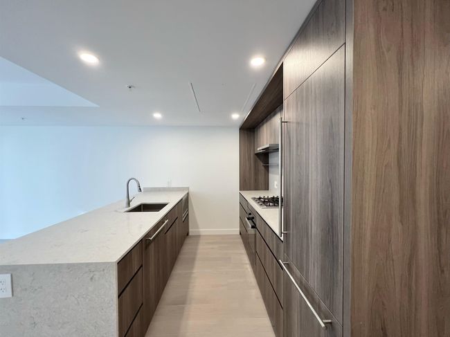 Kitchen featuring modern cabinets, stainless steel gas stovetop, recessed lighting, light wood-style flooring, and a peninsula | Image 5