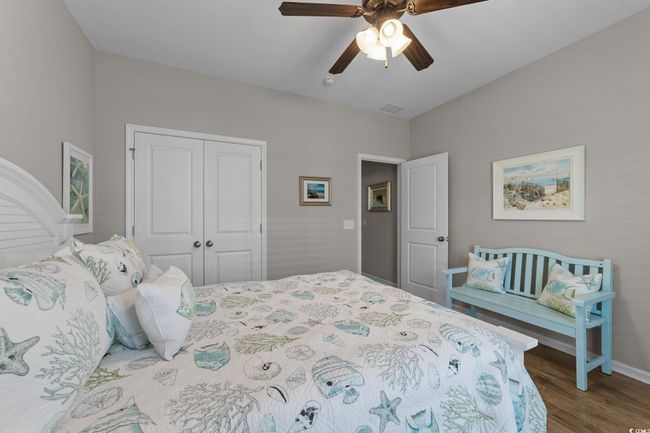 Bedroom with a closet, wood finished floors, baseboards, and ceiling fan | Image 26