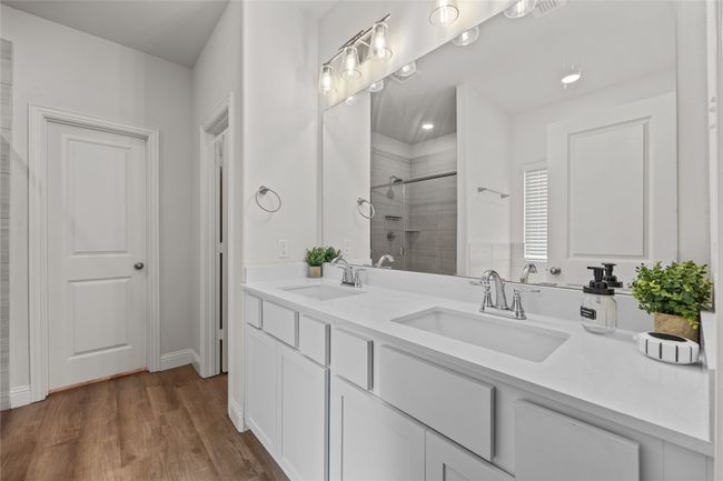Bathroom featuring a stall shower, wood finished floors, and double vanity | Image 19