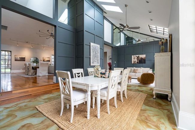 Just a few steps down from the Great room is the spacious Sunroom invites versatility- easily accomodating a cozy conversation area, dining area or multiple seating arrangements, all with outstanding back yard views and pasture. | Image 28