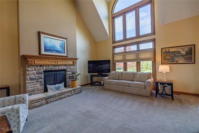 Living room featuring a towering ceiling, carpet floors, and a fireplace | Image 3