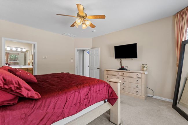 Bedroom with light carpet, baseboards, ceiling fan, and ensuite bath | Image 17