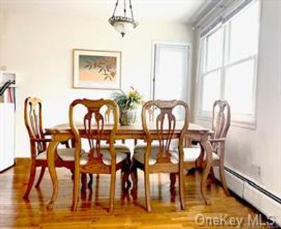 Dining room featuring a baseboard heating unit and wood-type flooring | Image 3