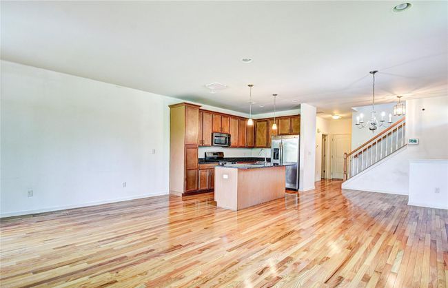 Kitchen featuring appliances with stainless steel finishes, open floor plan, and hardwood flooring | Image 8