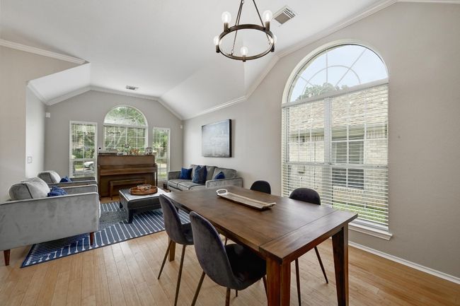 Formal Dining area featuring a chandelier, lofted ceiling, light wood-type flooring, crown molding, and baseboards | Image 14