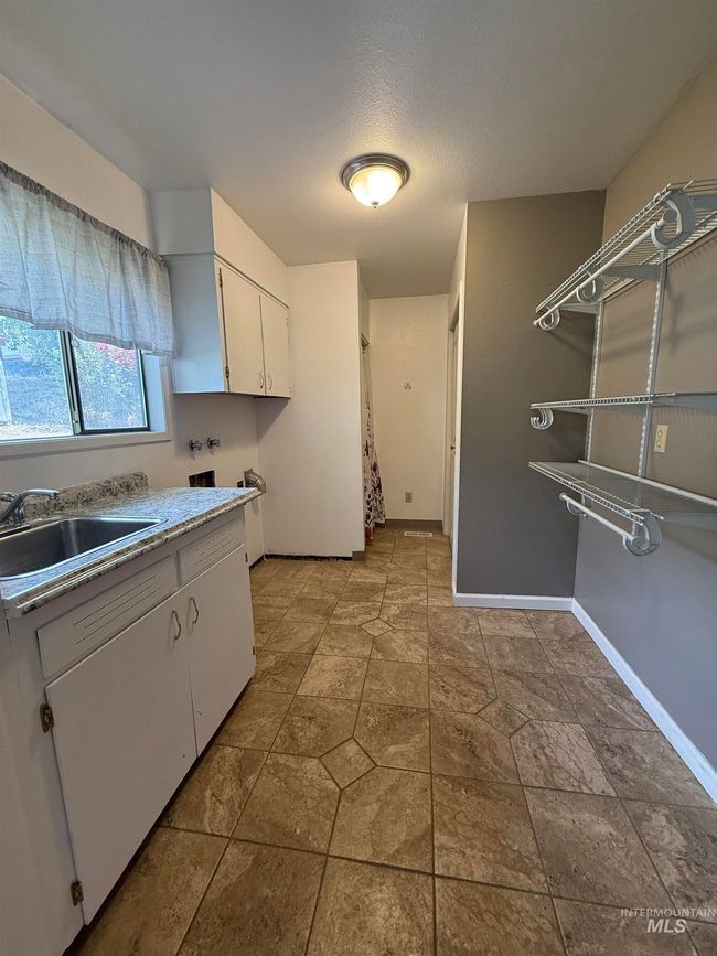 Kitchen with white cabinetry and light countertops | Image 20