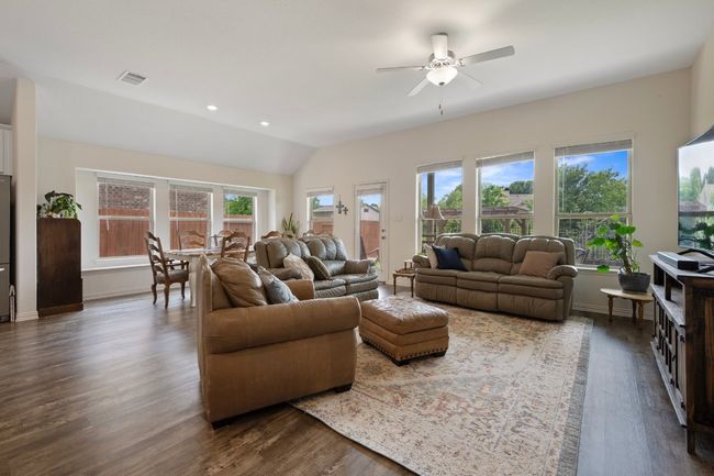 Living area with a ceiling fan, dark wood-style floors, vaulted ceiling, and baseboards | Image 10