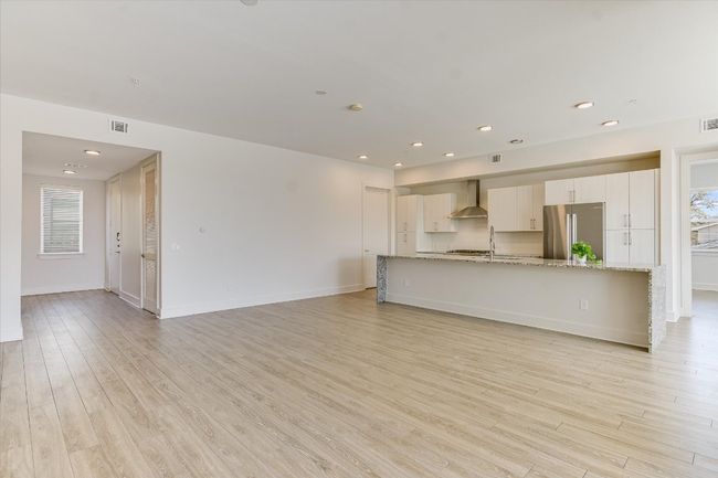 Unfurnished living room featuring light wood finished floors, visible vents, recessed lighting, and baseboards | Image 6