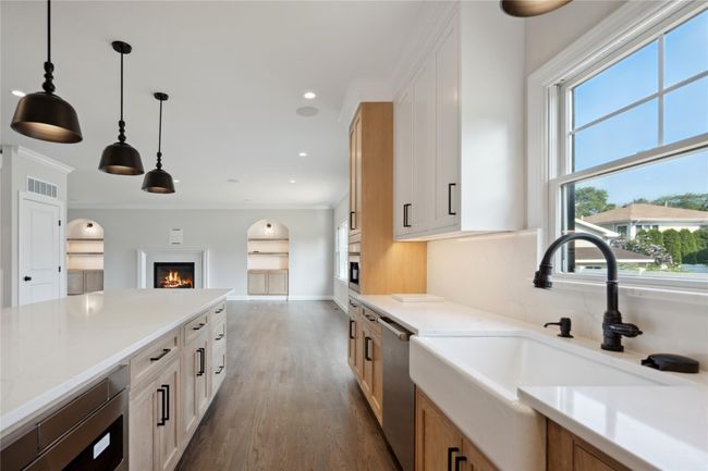Kitchen with stainless steel dishwasher, dark wood finished floors, decorative light fixtures, open floor plan, and recessed lighting | Image 6
