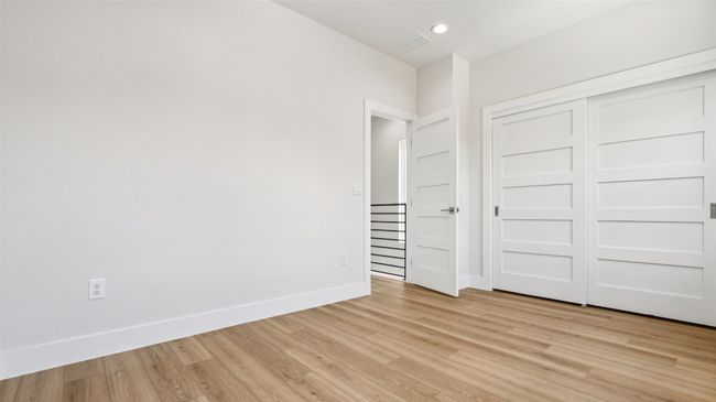Unfurnished bedroom with light wood finished floors, a closet, and recessed lighting | Image 21