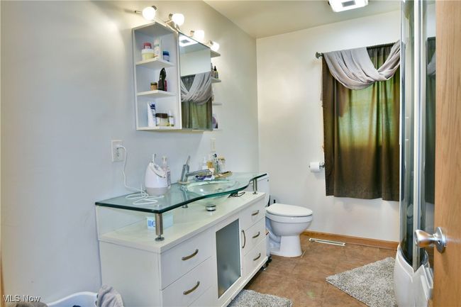 Bathroom featuring toilet, tile patterned floors, baseboards, and vanity | Image 22