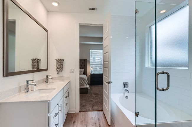 Ensuite bathroom featuring plenty of natural light, visible vents, two sinks | Image 16