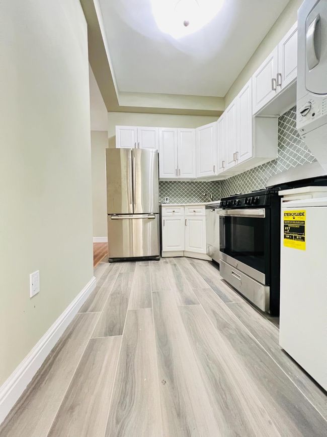 Updated kitchen with quartz countertops, French door refrigerator, gas range, dishwasher, and washer/dryer. | Image 6