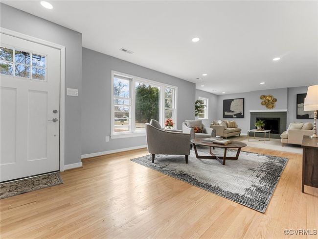 Living room featuring light wood-type flooring, a fireplace, visible vents, and baseboards | Image 7