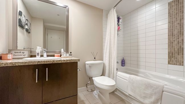 Bathroom with vanity, shower / tub combo with curtain, baseboards, toilet, and tile patterned flooring | Image 5