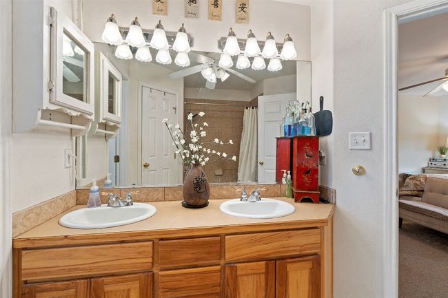 Bathroom featuring a ceiling fan, double vanity, and a tile shower | Image 29