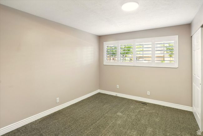 Unfurnished room with dark colored carpet and baseboards | Image 17