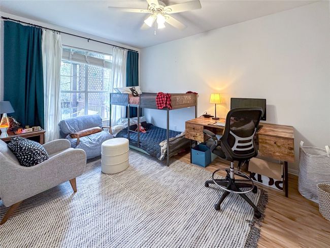 Bedroom featuring wood finished floors, a desk, and a ceiling fan | Image 16