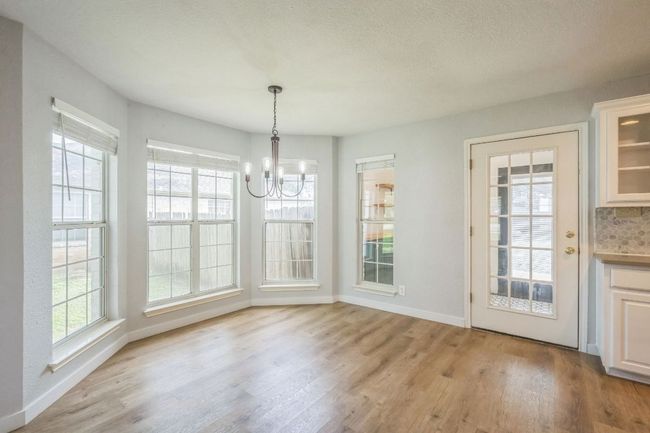 Dining area with a chandelier, light wood flooring, and healthy amount of natural light | Image 13