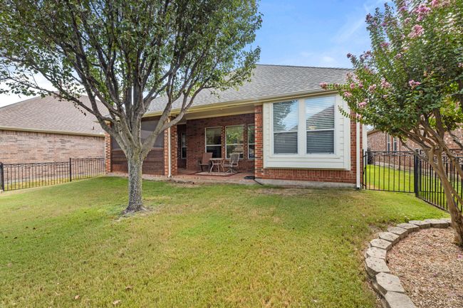 Rear view of house with brick siding, roof with shingles, and a patio | Image 24