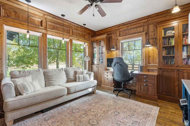 Office with ceiling fan, dark hardwood / wood-style flooring, and wood walls | Image 24