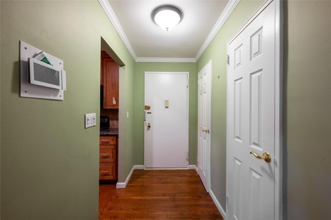 Doorway to outside featuring dark wood-type flooring, baseboards, and crown molding | Image 7