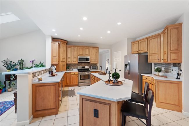 Ceramic tile, SS appliances, glass tile backsplash, large pantry and solid surface counters in the kitchen. | Image 7