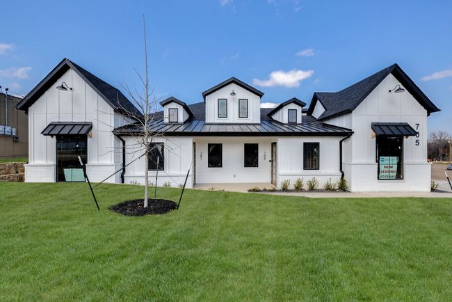 Back of property with a standing seam roof, board and batten siding, a yard, a metal roof, and roof with shingles | Image 22