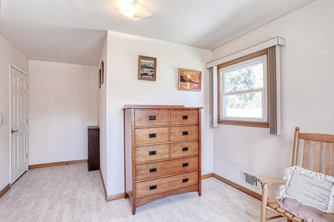 Bedroom with light wood-type flooring, visible vents, and baseboards | Image 20
