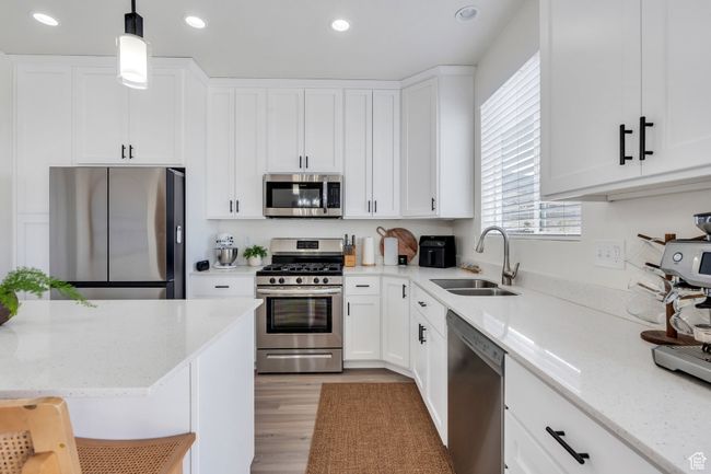Kitchen featuring a sink, white cabinets, and stainless steel appliances | Image 8