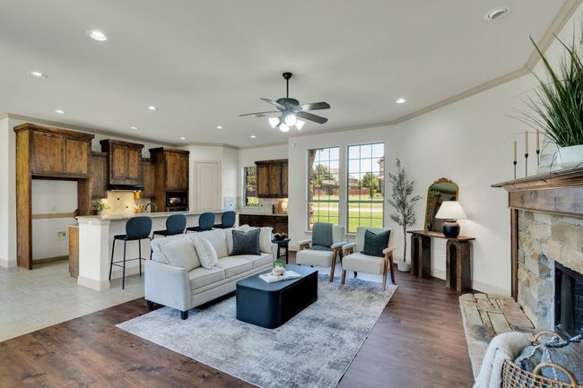 Living area featuring ornamental molding, a ceiling fan, recessed lighting, a fireplace, and light wood-type flooring | Image 5