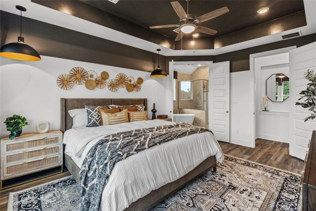 Bedroom with wood finished floors, connected bathroom, and a raised ceiling | Image 12