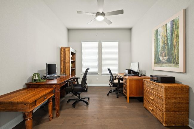 Office with dark wood finished floors and a ceiling fan | Image 7