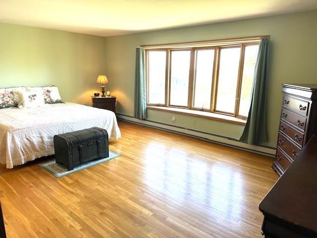 Bedroom featuring light hardwood / wood-style floors and a baseboard radiator | Image 12