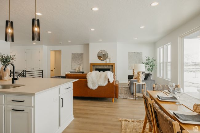 Kitchen featuring a sink, recessed lighting, light wood finished floors, white cabinetry, and light countertops | Image 15