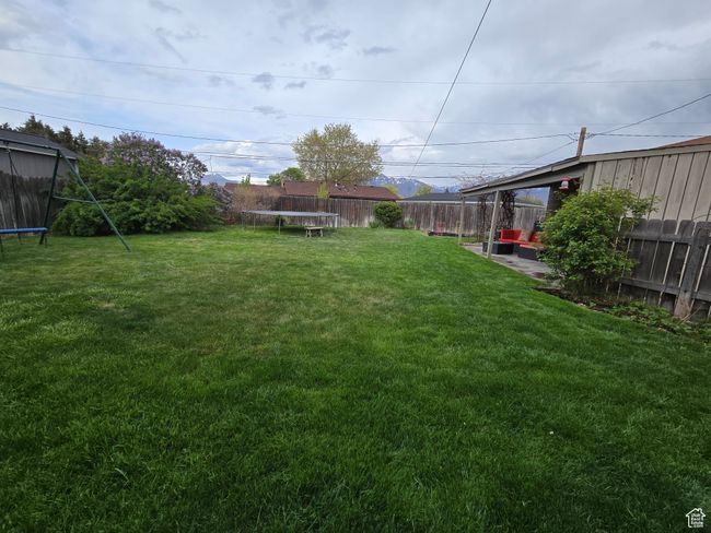 View of yard featuring a trampoline and a fenced backyard | Image 8