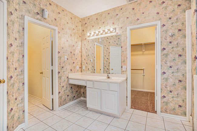 Additional view of vanity sink with linen closet and water closet to the left and large walk-in closet to the right. | Image 24