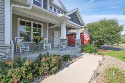 Imagine yourself relaxing on this charming front porch that welcomes you with open arms. | Image 3