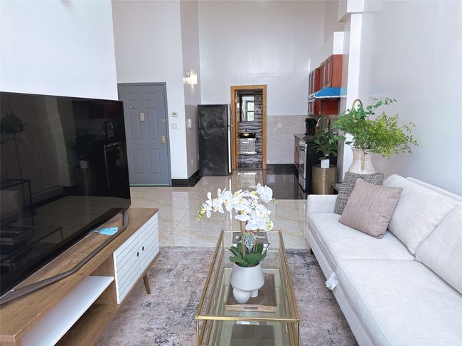 Living area featuring a high ceiling and wine cooler | Image 4