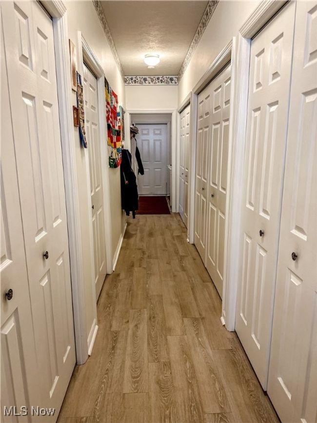 Corridor featuring light hardwood / wood-style floors and a textured ceiling | Image 7