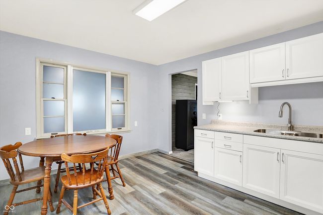 kitchen with a sink, light wood-style floors, light countertops, white cabinets, and baseboards | Image 9